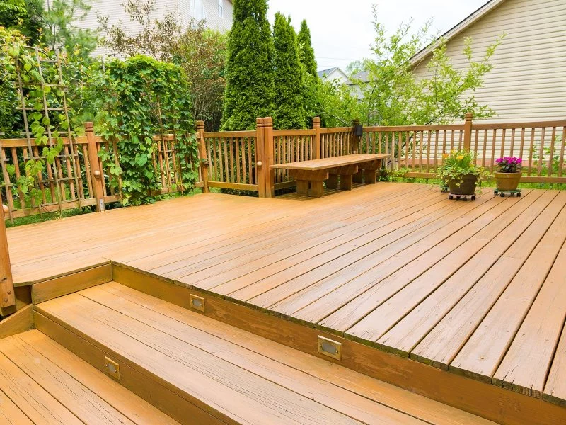 brown deck with wooden steps and plants